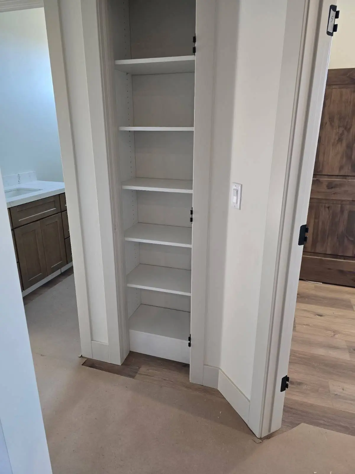 Built in linen closet shelving beside a bathroom vanity