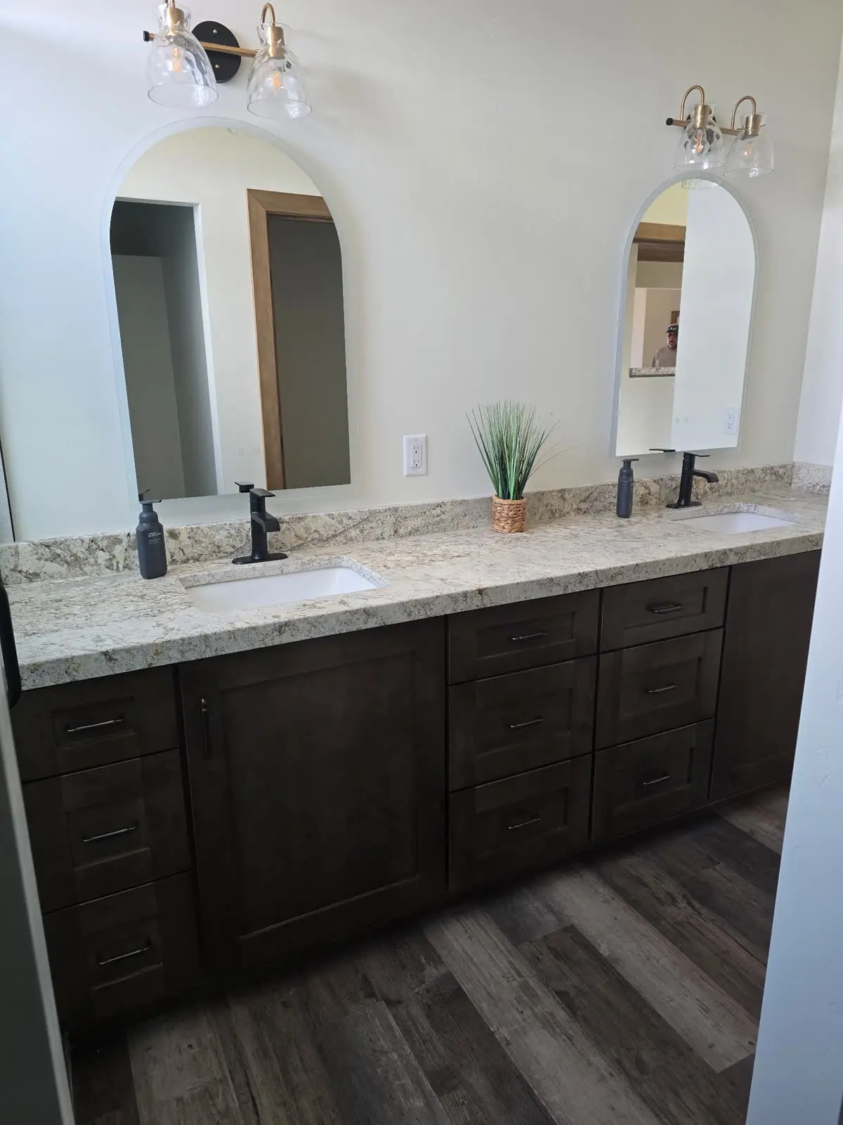 Dark wood double bathroom vanity with arched mirrors by DC Cabinets