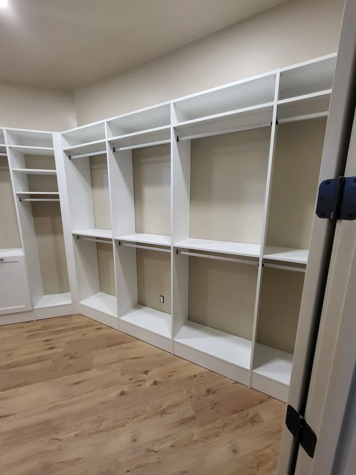 White closet system with hanging rods and shelves by DC Cabinets