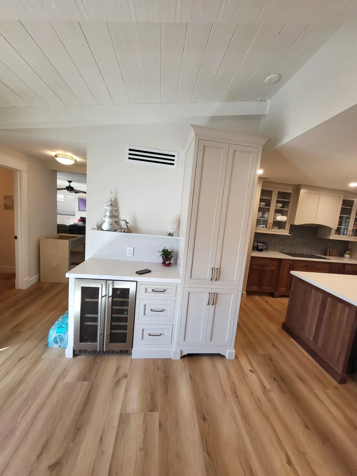 Cream kitchen cabinets with beverage fridge and tall cabinet by DC Cabinets