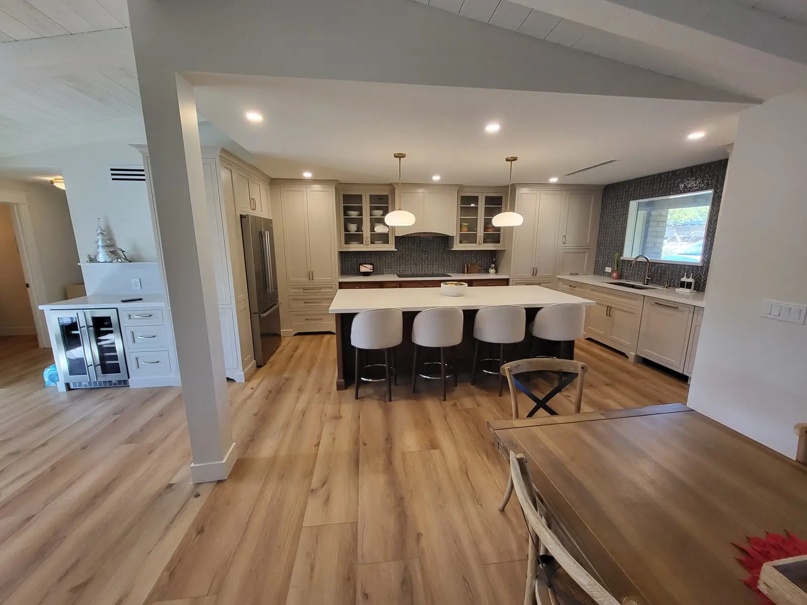 Cream kitchen cabinets with dark wood island and white quartz counters by DC Cabinets