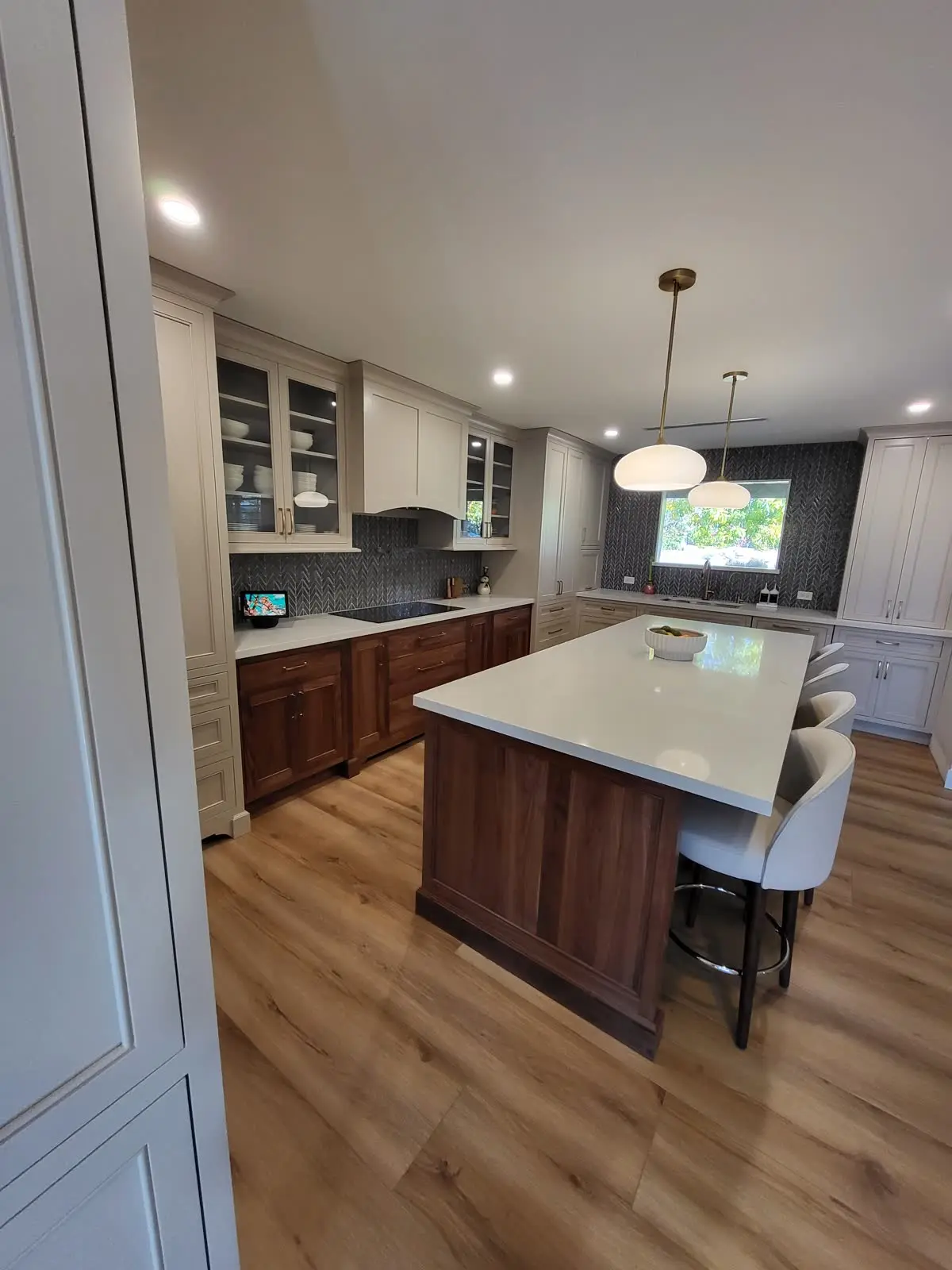 Kitchen island with dark wood cabinets and bar seating by DC Cabinets