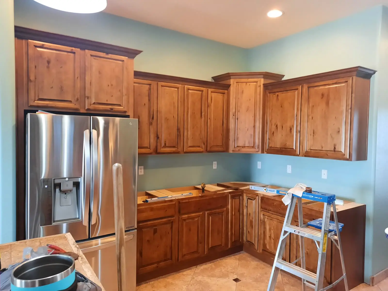 Knotty rustic wood kitchen cabinets with stainless refrigerator by DC Cabinets